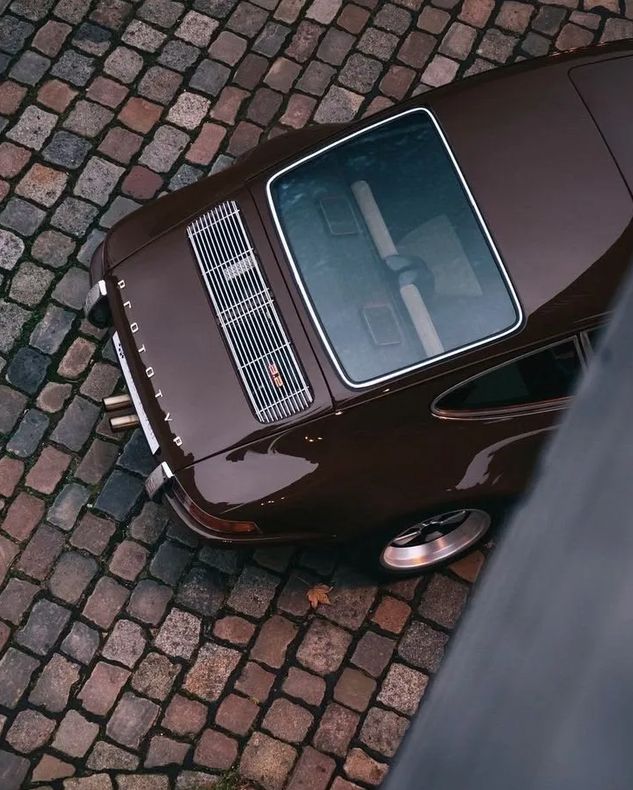Brauner Porsche auf Kopfsteinpflaster