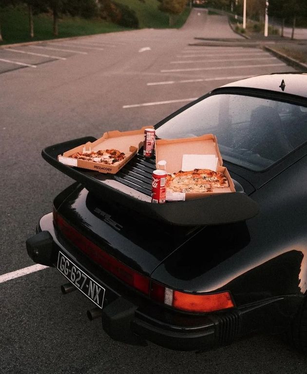 Schwarzer Porsche mit Pizza