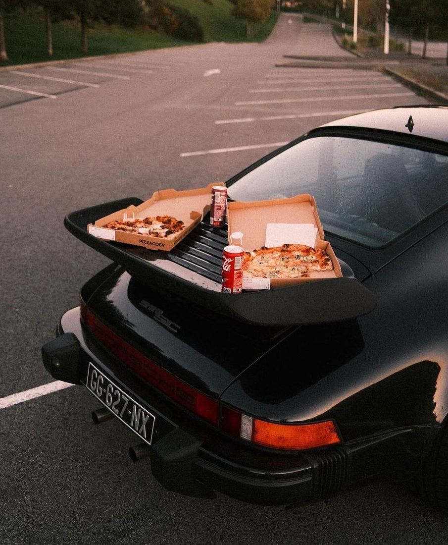 Schwarzer Porsche mit Pizza